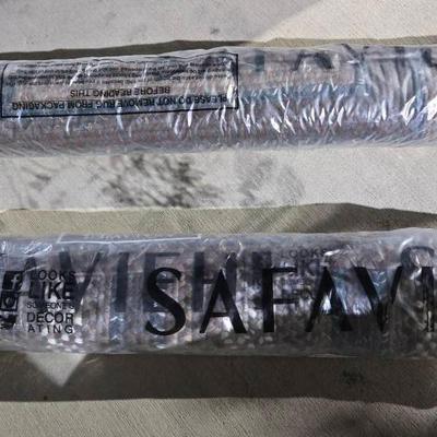two rolled-up Safavieh rugs in their original packaging