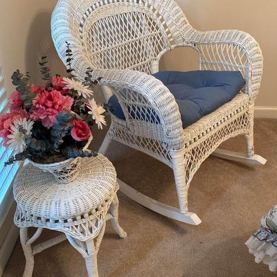 White Wicker Rocking Chair with Cushion, Table, and Floral Arrangement