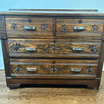 Four-Drawer Oak Dresser | Vintage (early 20th century) oak dresser with a rich dark finish, floral carvings, metal handles, and four...