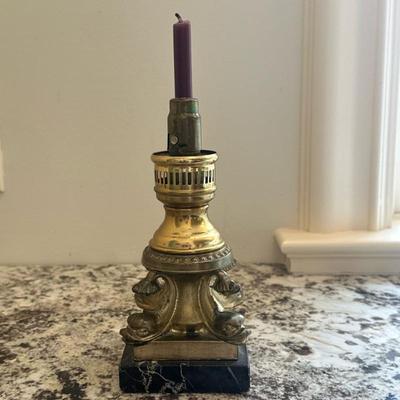 Brass Candlestick Table Lamp | Antique brass candlestick table lamp with intricate scrollwork, a dark marble base, and a purple candle. -...