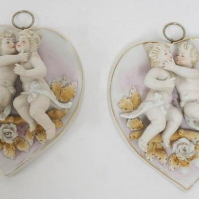 Sale Photo Thumbnail #122: 1122	PAIR OF AMART BISQUE HEART SHAPED WALL PLAQUES WITH KISSING CHERUBS MOUNTED ON TOP. EACH APPROXIMATELY 6 IN X 5 IN 
