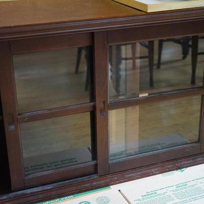 Contemporary style sliding glass door cabinet with center shelf. 