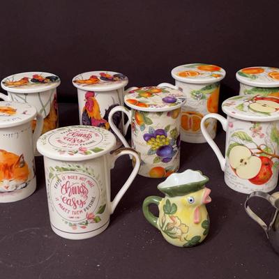 Nine Kent pottery tea mugs with lids and tea forte tea mug with strainer and little pict tle picture