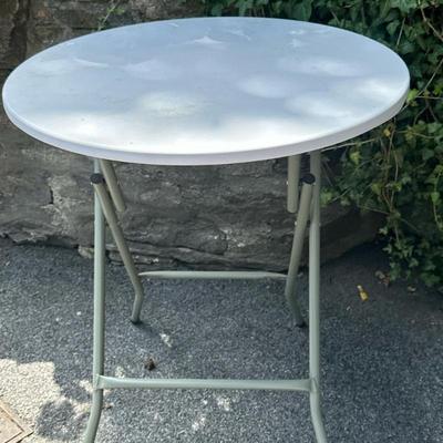 Round Folding Cocktail Table (1/2) | Round folding cocktail table with a white tabletop and gray steel frame, suitable for indoor or...