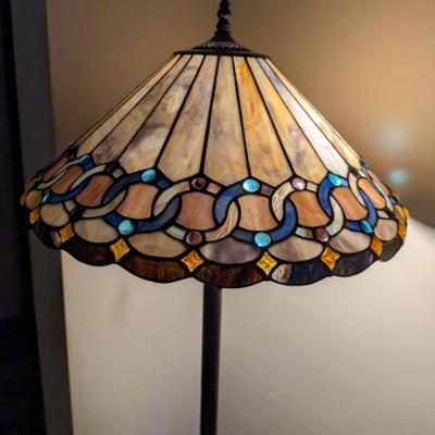 A stunning and elegant floor lamp in the classic Tiffany style. The lampshade features a beautiful, multi-colored stained glass design...