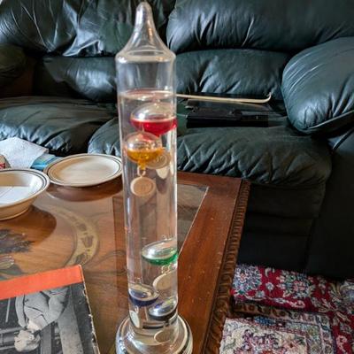 A beautiful and functional piece of scientific decor! This is a classic Galileo thermometer, a sealed glass tube with several colorful...