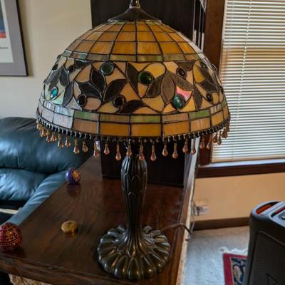 A stunning and elegant lamp in the classic Tiffany style. The lampshade features an intricate stained glass design of leaves and berries,...
