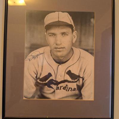 This is a striking black and white portrait of the legendary St. Louis Cardinals pitcher and Hall of Famer, Dizzy Dean. The photograph...