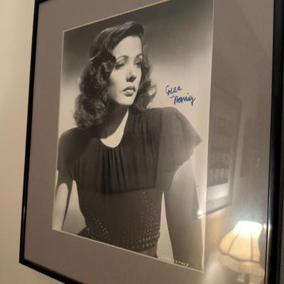 Framed black-and-white photo with a signature that appears to be from Gene Tierney, a stunning actress known for her roles in film noir...