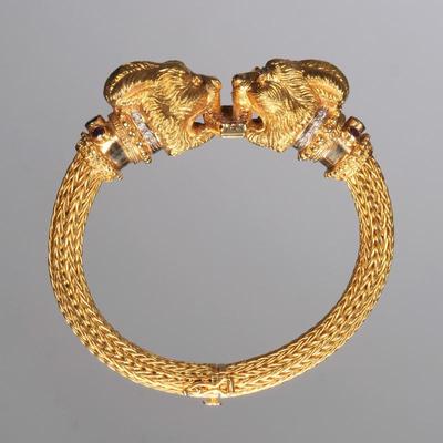 GREEK 18K DOUBLE CHIMERA BRACELET | Flexible, woven 18k yellow gold bracelet, featuring two large Chimera heads, each set with ruby (or...