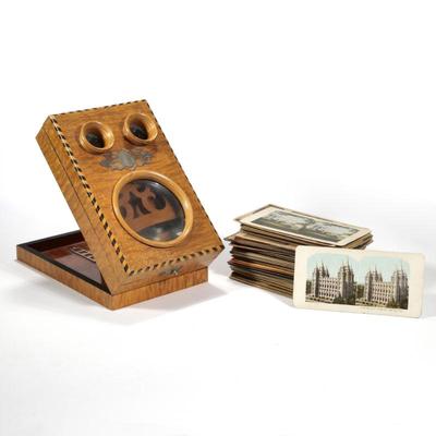 ANTIQUE FOLDING STEREOSCOPIC VIEWER & SLIDES | One large lens and two eyepieces set into a richly figured wood top with contrasting...