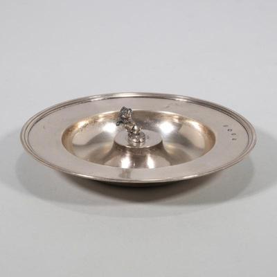 THEO FENNEL STERLING SILVER 'BEGGING DOG' ASHTRAY, LONDON | A round ashtray with wide rim, raised center mounting a figure of a...