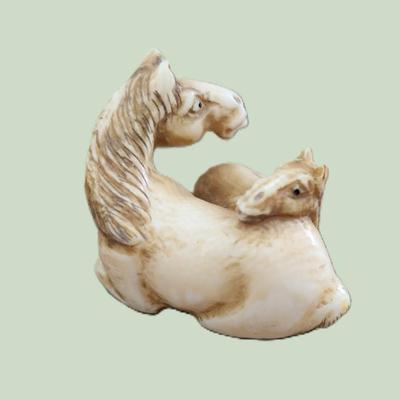 Sale Photo Thumbnail #58: Antique Japanese carved netsuke of a mare and foal. Artist signed. With Himotoshi (two holes) used for the cord to attach the Netsuke to the obi. Measures 2". 