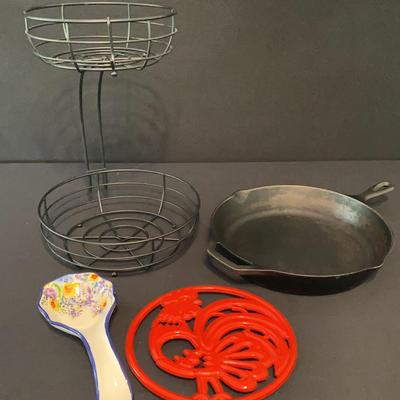 Kitchen Items: Cast Iron Pan, Two Tier Fruit Basket, Trivet And Spoon Rest
