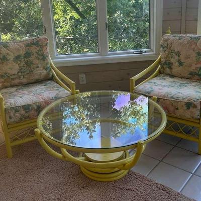 Two Yellow Patio Lounge Chairs With Floral Cushions And Matching Spinning Glass Top Coffee Table