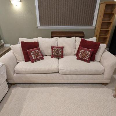 Lot #90 - Cream Colored Sofa with Decorative Red Pillows and Included Slip Covers