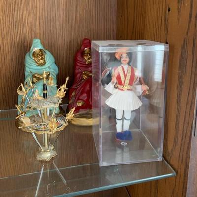 Vintage Greek Doll, Catholic Monk Statues, And Sword Cocktail Display