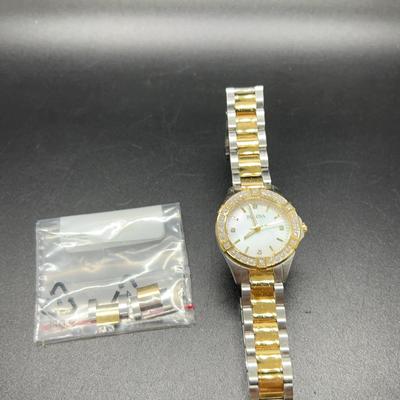 Womens 2 toned Bulova watch with crystal diamond faceand white background.