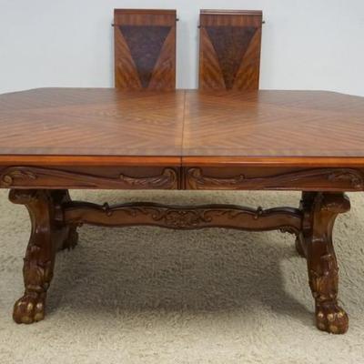 Sale Photo Thumbnail #257: 1255	OAK DINING TABLE WITH BOOK MATCHED VENEER TOP, CARVED SKIRT, CARVED PAW FEET WITH GILT ACCENTS, AND 2 LEAVES, TABLE APPROXIMATELY 78 IN X 46 IN X 32 IN H, EACH LEAVE APPROXIMATELY 16 IN W
