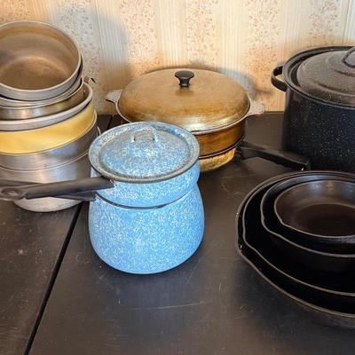 A Large Assortment Of Aluminum Pans, Cast Iron Skillets, And Granite Ware