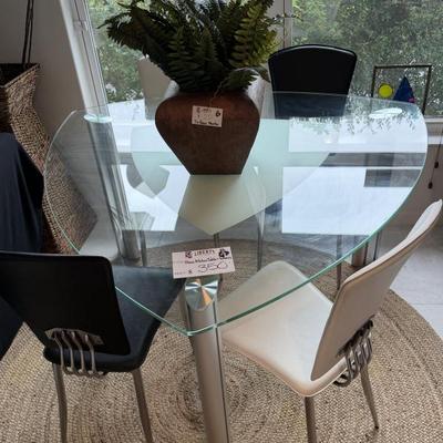 Mid-century modern glass-top dining table and chairs add a stylish touch.