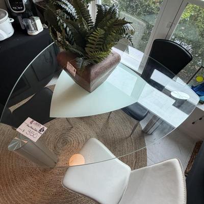 Mid-century modern glass-top dining table and chairs add a stylish touch.