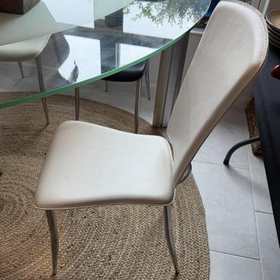 Mid-century modern glass-top dining table and chairs add a stylish touch.