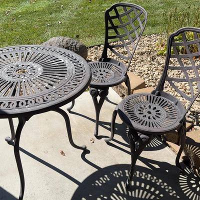 Iron bistro table and chairs with umbrella hole in the table