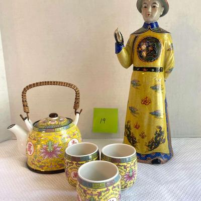 Tall Asian figurine and teapot with cups, all in yellow
