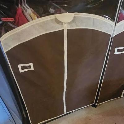 Storage Rack w/ Clothes Hanging inside. 