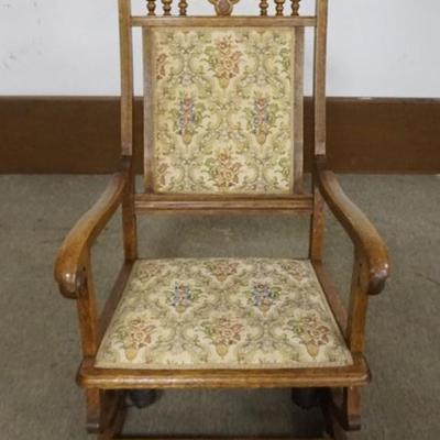 Sale Photo Thumbnail #188: 1188	OAK PLATFORM ROCKER WITH CARVED OAK LEAVES, TURNED SPINDLES AND UPHOLSTERED SEAT AND BACK, APPROXIMATELY 24 IN X 28 IN X 41 IN H

