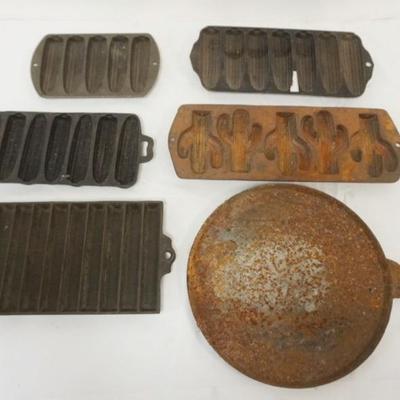 Sale Photo Thumbnail #111: 1111	ASSORTED ANTIQUE CAST IRON CORN BREAD MOLDS, 1 WITH CACTUS AND CAST IRON GRIDDLE, LARGEST APPROXIMATELY 12 IN X 16 IN. 1 MARKED GRISWOLD #273
