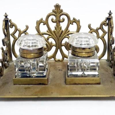 Sale Photo Thumbnail #1: 1001	ANTIQUE DOUBLE INKWELL W/CUT GLASS INKWELLS IN ORNATE BRASS BASE, APPROXIMATELY 6 1/2 IN X 4 1/2 IN X 4 IN HIGH
