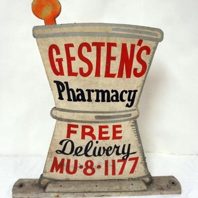 Sale Photo Thumbnail #67: 1067	WOOD APOTHECARY STORE SIGN *GESTEN'S PHARMACY* W/IMAGE OF MORTAR & PESTLE, APPROXIMATELY 27 IN X 29 IN HIGH
