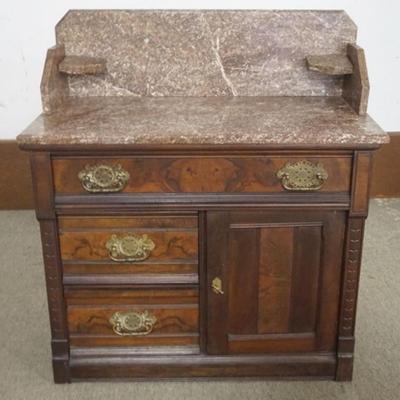 Sale Photo Thumbnail #196: 1196	WALNUT VICTORIAN MARBLE TOP STAND WITH BROWN MARBLE, BACK SPLASH, LAMP SHELVES, 3 BURL WOOD FRONT DRAWERS AND 1 DOOR, APPROXIMATELY 34 IN X 17 IN X 38 IN H
