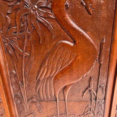 Paneled door with heron and fish carving.