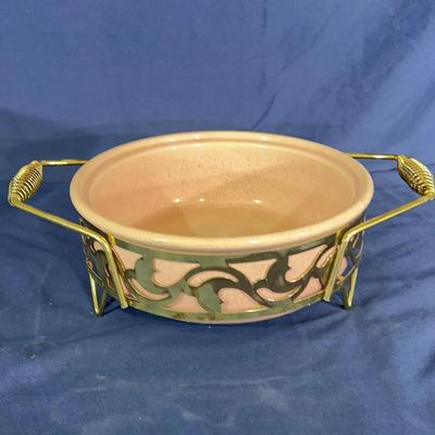 Vintage pink speckled Bauer casserole dish with a decorative metal stand and coiled handle