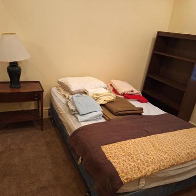 Twin bed. Linens. Night stand.  Bookshelf.