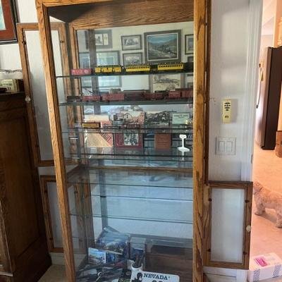 Lockable oak glass display cabinet with 7 glass shelves, measures 34" w x 14" d x 76" h. $150