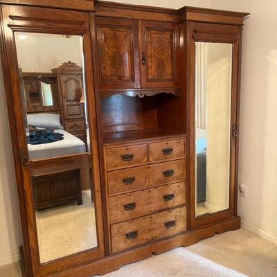 Beautiful antique wooden wardrobe featuring mirrored doors and multiple drawers. Excellent condition, with a few small blemishes....