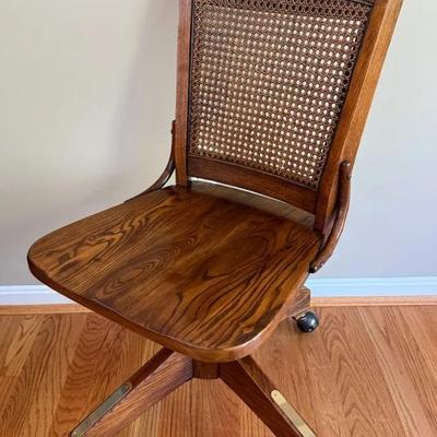 Vintage Cane Back Rolling Banker’s Chair With Brass Accents