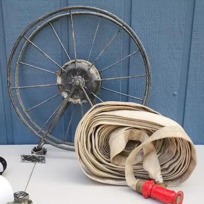 Vintage Fire Hose with Brass Coupling and Red Nozzle on Metal Reel
