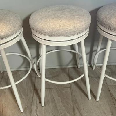 Lot 457: Set of 3 Modern White Metal Swivel Bar Stools with Light Gray Cushioned Seats