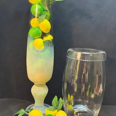 Glass drink dispenser and large vase full of citrus