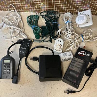 Small Lot Of Assorted Extension Cords, Timers, And Battery Charger
