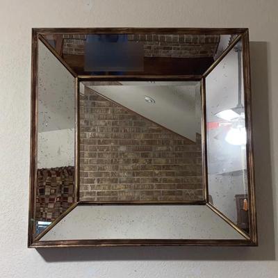 Square gold-toned wall mirror with an antique or distressed finish and beveled accent panels