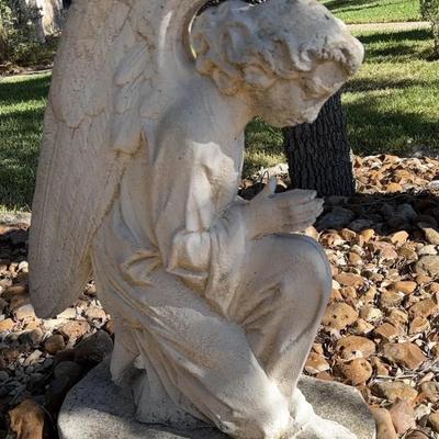 Garden statue of a kneeling, praying angel. 