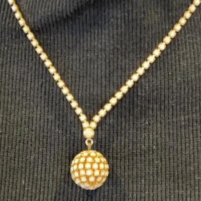 Gold-tone necklace with a spherical, stone-encrusted pendant