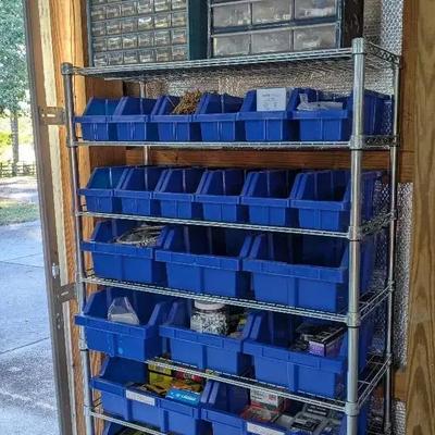 Eight-Tier Rolling Metal Shelf with Blue Storage Bins and Hardware Contents