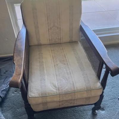 English Regency-style caned armchair with a striped upholstered cushion